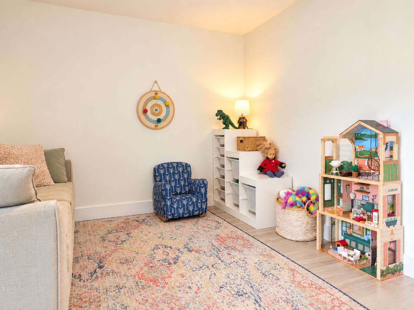 Rachel's playroom with a soft couch, patterned rug, child-size chair, and open shelves of toys